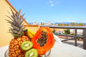 a pineapple and a papaya sitting on a table at El Veril 84 Bahia del Duque in Adeje