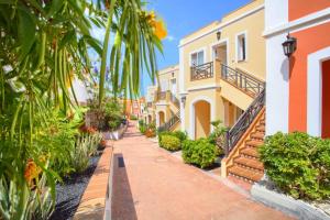 a row of houses with palm trees and a sidewalk at El Veril 84 Bahia del Duque in Adeje