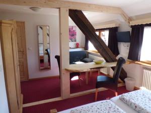 a room with a desk and a bed and a room at Pension Wiesengrund in Schluchsee