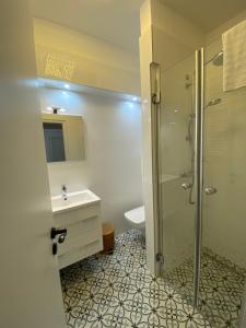 La salle de bains est pourvue d'une douche et d'un lavabo. dans l'établissement Home Sweet Apartment, à Bük
