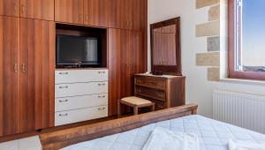 a bedroom with a dresser and a tv and a bed at Ktima Edem in Ramní