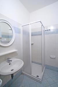 uma casa de banho com um chuveiro e um lavatório. em Hotel Giove em Cesenatico
