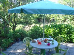 a table with a blue umbrella on a patio at Casa da Penalva in Santa Cruz do Lima +3 photos