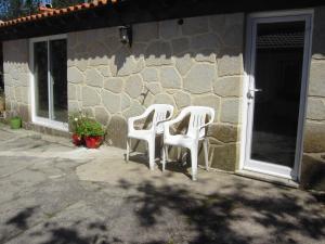 two white chairs sitting outside of a building at Casa da Penalva in Santa Cruz do Lima
