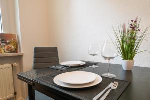 - une table avec deux assiettes et deux verres à vin dans l'établissement Blue Chili 18 Zentrales CITY-Apartment am Hasselbachplatz, 4 Personen, à Magdebourg 17 autres photos