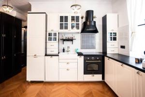 een keuken met witte kasten en zwarte apparaten bij NEW! Luxurious apartment BELLA LUX in city center in Split