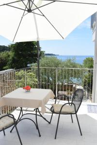stół i krzesła z parasolem na balkonie w obiekcie Buric House - Apartments Klasik and Studio Mini w Rovinj