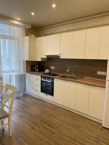 a kitchen with white cabinets and a sink at White House apartment in Lviv