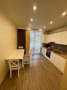 a kitchen with a table and chairs in a room at White House apartment in Lviv +19 photos
