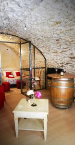 d'une chambre avec un tonneau, une table et une table sidx sidx sidx dans l'établissement Chambre d hote de charme avec plein d authenticité du 13 ème siècle, à Châteauneuf-du-Pape