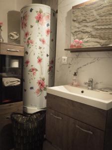 baño con lavabo y nevera con flores. en Chambre d hote de charme avec plein d authenticité du 13 ème siècle, en Châteauneuf-du-Pape