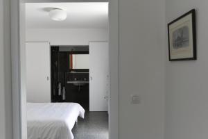biała sypialnia z łóżkiem i lustrem w obiekcie Buric House - Apartments Klasik and Studio Mini w Rovinj