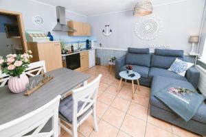 a kitchen and a living room with a couch and a table at Ferienwohnung Ententeich in Fehmarn