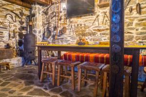 eine Bar mit einer Steinmauer und einem Holzofen in der Unterkunft Djurdjevina Family Farm in Kolašin