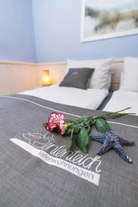 - une chambre dotée d'un lit avec une fleur et une étoile de mer dans l'établissement Ferienwohnung Ententeich, à Fehmarn