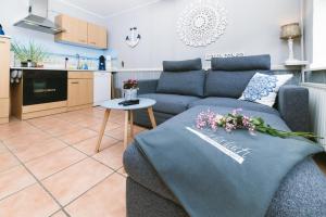 a living room with a blue couch and a kitchen at Ferienwohnung Ententeich in Fehmarn