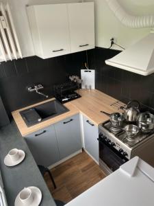 a kitchen with white cabinets and a stove at 300 metrów od plaży / 300 meters from the beach in Gdańsk