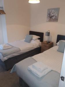 a hotel room with two beds and two lamps at Ty Dre Town House in Caernarfon