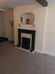 a living room with a fireplace and a large mirror at Ty Dre Town House in Caernarfon