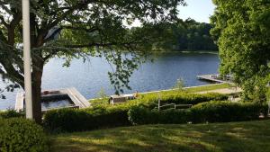 uma vista para um lago com uma casa e uma doca em Studio mit Seeblick em Bad Segeberg