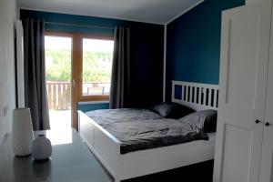 Un dormitorio con una cama con paredes azules y una ventana en FeWo Krämer, en Plein
