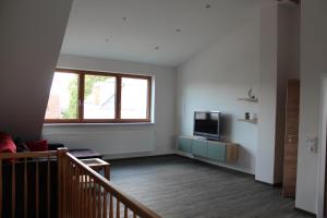 an empty living room with a tv and a window at FeWo Krämer in Plein