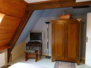 a attic room with a television and a cabinet at Le Logis de la Cour de Bretagne au Port de Dinan Lanvallay in Lanvallay
