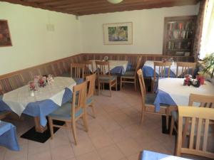 ein Esszimmer mit Tischen und Stühlen mit blauen Servietten in der Unterkunft Aparthotel Garni Schranz in Wald im Pinzgau