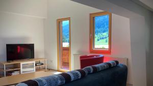 a living room with a couch and a television at Haus Diezig in Blitzingen