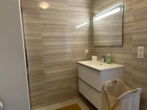een badkamer met een wastafel en een spiegel bij Appartement vue mer panoramique près de Porticcio in Pietrosella
