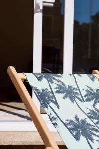 Una silla con un estampado de palmeras. en Muratello Appart 1, en Porto Vecchio