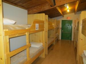 um quarto com beliches e uma porta verde em HI Kananaskis Wilderness - Hostel em Kananaskis Village