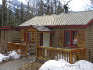 eine Blockhütte mit einer Veranda und einer Terrasse in der Unterkunft HI Rampart Creek - Hostel in Saskatchewan River Crossing