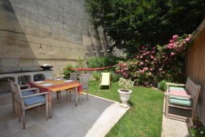 a patio with a table and chairs and flowers at Maison Tarascon in Tarascon