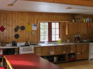 a kitchen with wooden cabinets and a window in it at HI Rampart Creek - Hostel in Saskatchewan River Crossing