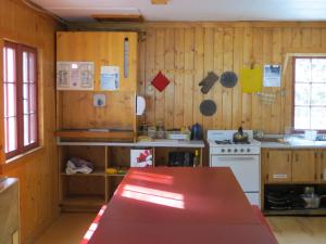 una cocina con paredes de madera y una mesa. en HI Rampart Creek - Hostel, en Saskatchewan River Crossing