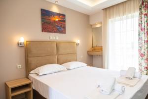 a bedroom with a bed with two white pillows at Sun Studios Pieria in Paralía Skotínis