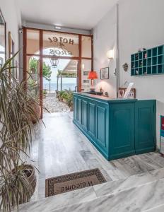um quarto com um balcão verde e uma porta para um pátio em Eros Beach Hotel em Benitses