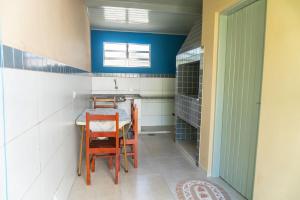 a kitchen with a table and chairs and blue walls at Apartamentos Incríveis Primeira Quadra Mar WiFi in Ubatuba