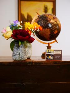 a table with a vase of flowers and a globe at Pension Helma in Bad Neuenahr-Ahrweiler