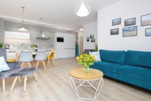 a living room with a blue couch and a table at La Playa apartament przy plaży in Pobierowo +20 photos