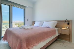 a bedroom with a large bed with a large window at Katakis LuxuryVillas in Chania