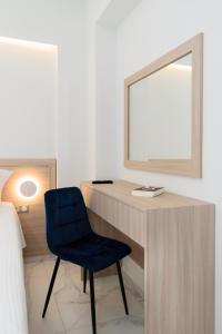 una scrivania con specchio e sedia blu in una stanza di Katakis LuxuryVillas a Chania