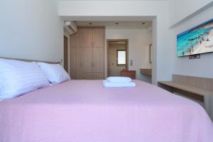 ハニア・タウンにあるKatakis LuxuryVillasのベッドルーム1室(ピンクの毛布付きの大型ベッド1台付)