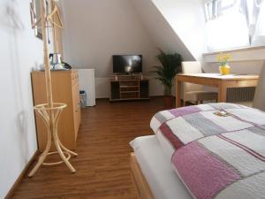 a bedroom with a bed and a desk with a television at Thai Tawan in Rheinhausen