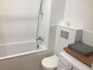 華沙的住宿－Studio Apartment，白色的浴室设有卫生间和淋浴。