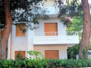 een wit gebouw met oranje deuren en een balkon bij via Ancona a 50mt dal mare in Marcelli