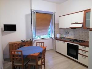 een kleine keuken met een tafel en een tafel met stoelen bij via Ancona a 50mt dal mare in Marcelli