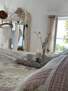 a bedroom with a bed with a candle and a mirror at Robinson house Leticia in Čunski