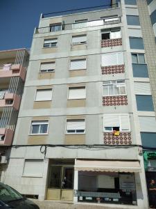 un alto edificio grigio con finestre e un negozio di Oriente DNA Studios III a Lisbona
